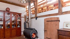 Ein Zimmer mit Kaminofen, Holzschränken und einer Holztür.