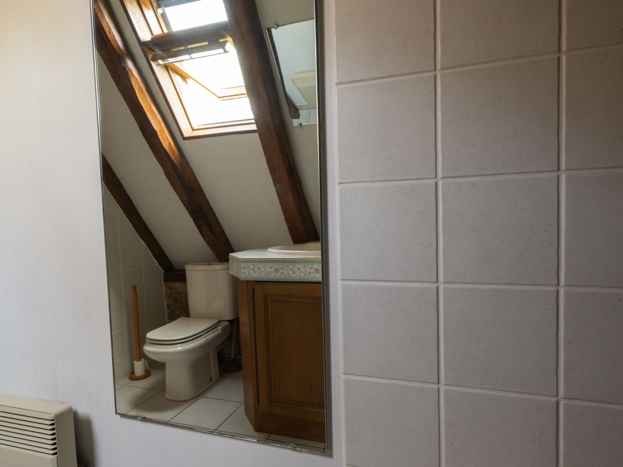 Une salle de bain avec des toilettes, un lavabo et un miroir.