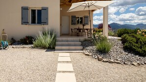 A two-story house with a patio, outdoor seating, and a view of mountains. - Les Hauts de Jallia by Interhome (Nyons)