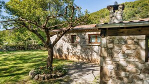 A stone house with a sloped roof, a small window, and a tree in the foreground. - Les Galets by Interhome (Valgorge)