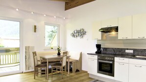 A modern kitchen with white cabinets, a built-in oven, and a coffee machine. - Lili - Top 1 by Interhome (Längenfeld)