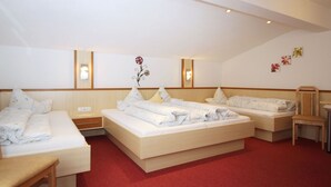 A hotel room with three beds, a wooden headboard, a red carpet, and a wall-mounted light fixture. - Alpenheim Haid by Interhome (Längenfeld)