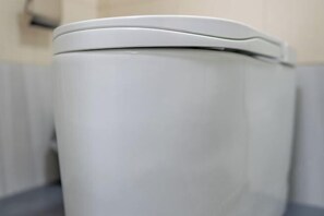 Un bote de basura blanco en un baño.