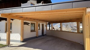 Ein Gebäude mit einer Holzpergola, einem Schild und Blick auf eine Berglandschaft.