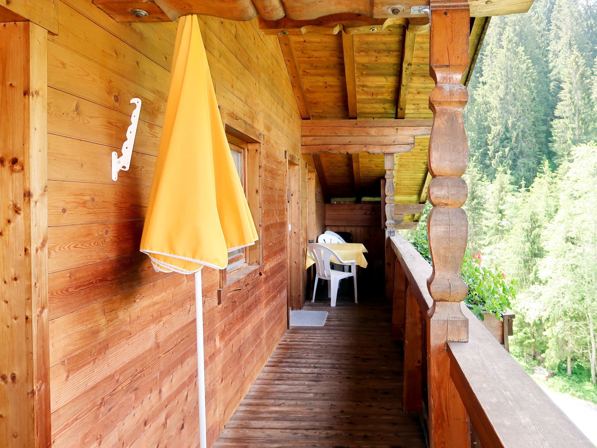 Una cabaña de madera con una escalera de madera que lleva a un balcón.