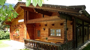Eine Holzhütte mit Balkon und Holzveranda, sowie ein Schild, das anzeigt, dass es sich um ein Restaurant handelt.