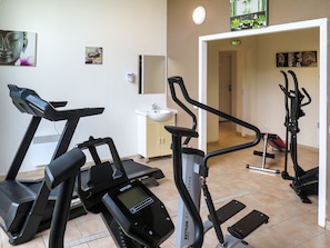 A gym with treadmills, stationary bikes, and a weight machine.