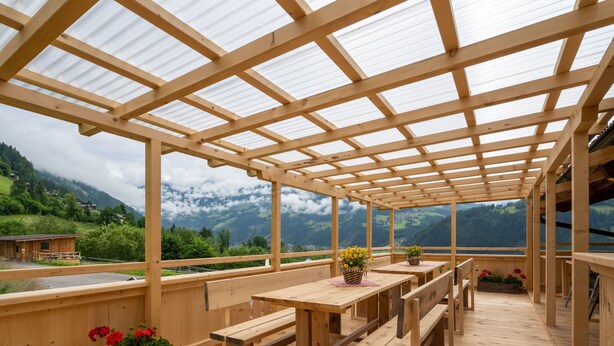 An outdoor wooden deck with benches and tables, overlooking a mountainous landscape. - Talbach by Interhome (Mayrhofen)