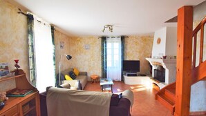 A cozy living room with a sofa, TV, and fireplace. - Madaillan by Interhome (Prayssas)