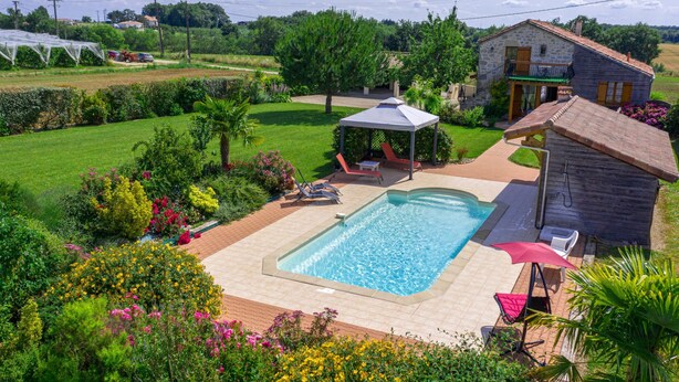 A swimming pool with a sunshade, surrounded by a garden with various plants and flowers. - Madaillan by Interhome (Prayssas)