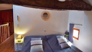 A bedroom with a bed, a bedside table, a lamp, a mirror, and a window. - Madaillan by Interhome (Prayssas)