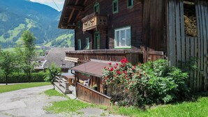 A rustic wooden building with a balcony, a signboard, and a view of the surrounding landscape.