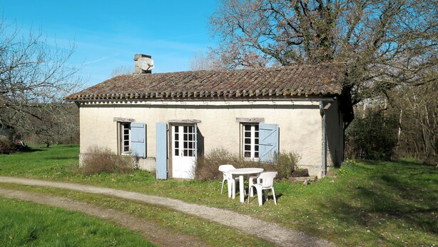 A rustic house with a tiled roof, a chimney, and a small table with chairs outside. - Marquefabe by Interhome (Labretonie)