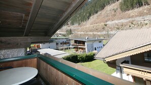 Un balcone con vista su una collina e degli edifici.