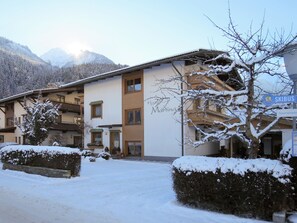 A hotel with a snow-covered entrance, a sign for 'Skibus', and a mountainous backdrop. - Martina by Interhome (Mayrhofen)