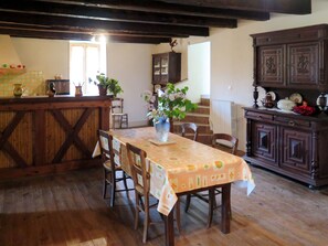 Enjoy meals in this charming dining area with a wooden table, floral decor, and exposed beams.