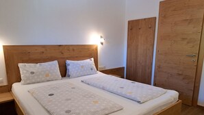 Un lit simple avec une tête de lit en bois et deux tables de chevet.