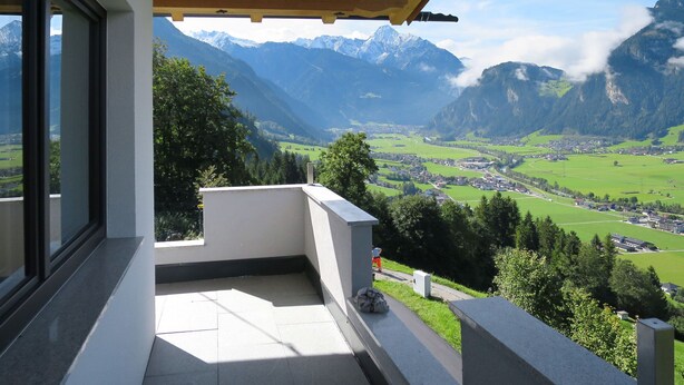 Uma varanda com vista para um vale e montanhas.