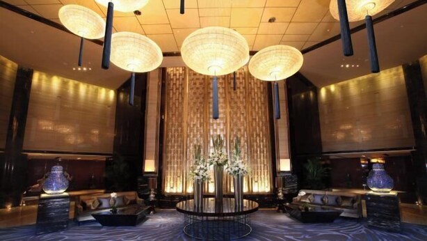 A lobby with a central round table, multiple hanging lamps, and a patterned carpet. - Tangla Hotel Tianjin (TIANJIN)