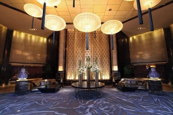 A lobby with a central round table, multiple hanging lamps, and a patterned carpet. - Tangla Hotel Tianjin (TIANJIN)