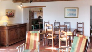 A dining area with striped chairs, a wooden table, and a cabinet. - Roque Piquet by Interhome (L'Honor-de-Cos)