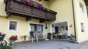A yellow building with a wooden balcony, potted plants, and outdoor seating. - Brugger by Interhome (Mayrhofen)