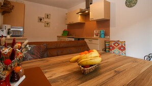 A modern kitchen with a wooden table, a microwave, and a clock on the wall. - Apartment Bair by Interhome (Mayrhofen)