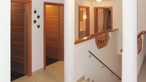 Una escalera con barandillas y pasamanos de madera, que lleva a un piso superior.