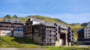 Ett hotell med flera våningar, balkonger och en vacker bergsutsikt.