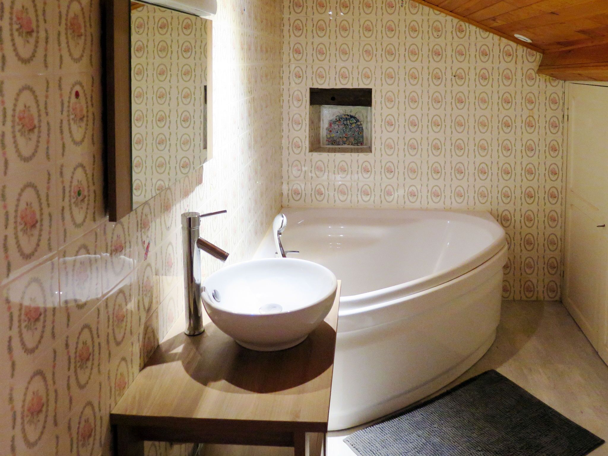 Un baño con una bañera independiente, un lavabo y un espejo.