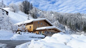 A wooden chalet with a sloped roof, surrounded by snow-covered trees and a mountain backdrop. - Talbach by Interhome (Mayrhofen)