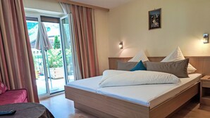 Une chambre d’hôtel avec un grand lit, une table de chevet, une chaise et une vue sur l’extérieur.