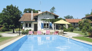 A swimming pool with a house in the background.