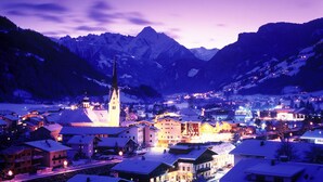 Une ville qui se distingue par son église imposante et ses bâtiments couverts de neige, le tout étant entouré de montagnes.