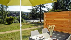 A table with a view of a river and houses in the background.