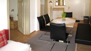 Un soggiorno moderno con zona pranzo, che include un divano, un tavolino da caffè e un tavolo da pranzo con sedie.