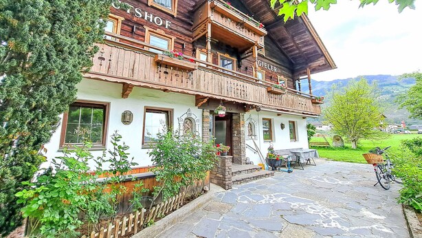 Un edificio in legno tradizionale con un balcone e un'insegna che riporta la scritta "GIELER".
