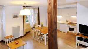 Une cuisine moderne avec des armoires blanches, un four encastré et un four à micro-ondes.