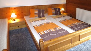 Ein Schlafzimmer einer Holzhütte mit einem Doppelbett, zwei Nachttischen mit Lampen und einem Heizkörper.