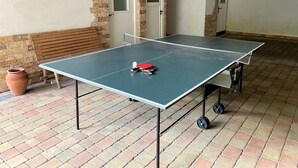 A ping pong table with a net, a wooden bench, and a potted plant. - Eberharter by Interhome (Zell am Ziller)