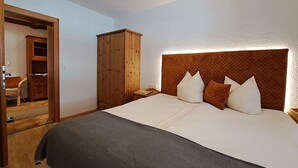 Une chambre à coucher avec un grand lit, une armoire en bois et un meuble avec une porte-miroir.