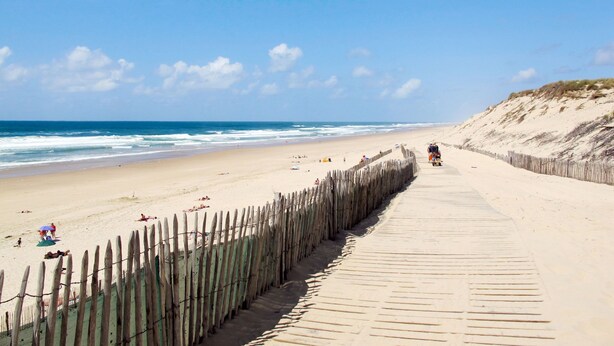 A beach with a wooden boardwalk leading to the water. - Tuilières by Interhome (Pauillac)