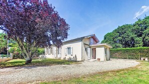 A two-story house with a gravel driveway and a small garden area. - L‘Estuaire by Interhome (Begadan)