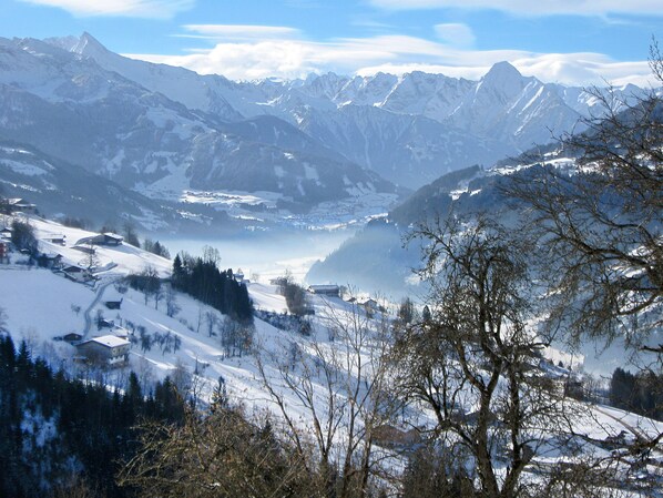 Un paisaje montañoso con picos nevados y un valle.