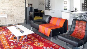 Ein modernes Wohnzimmer mit einer Couch, einem Couchtisch und einem gemusterten Teppich.