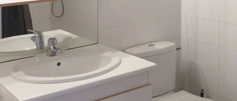 Ein Badezimmer mit Waschbecken, Spiegel und Toilette.