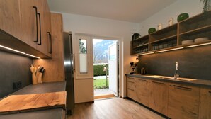 Une cuisine moderne avec des meubles en bois, un réfrigérateur en acier inoxydable et un four encastré.