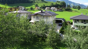 A residential area with houses, a church, and green hills in the background. - Apartment Wurm by Interhome (Fügen)