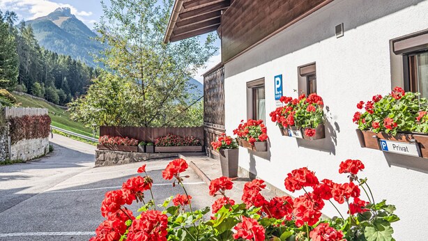 A building with a white exterior, wooden balcony, and flower boxes. - Apartment Sonja by Interhome (Neustift im Stubaital)