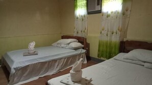 Una stanza con due letti, ognuno con una coperta e dei cuscini bianchi. Su un letto c'è un asciugamano, sull'altro un asciugamano piegato.